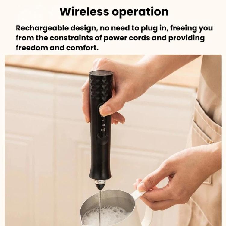 Black wireless milk frother mixing above a bowl with whisk head