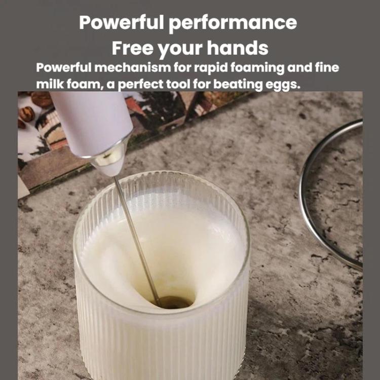White whisk beater frothing milk in a cup