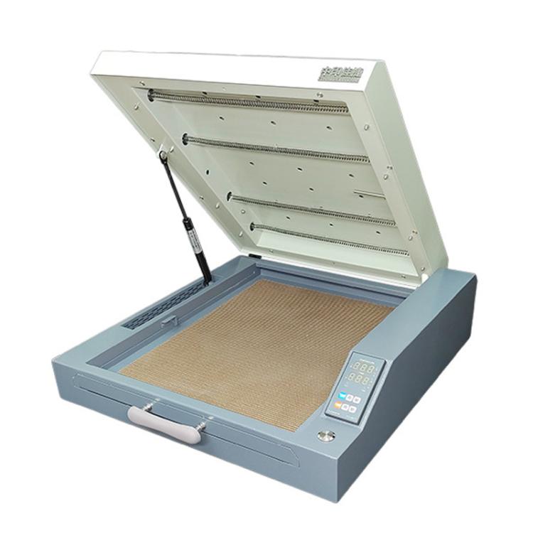 Mini heat drying oven with open lid and beige transfer film on the baking tray
