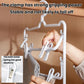 White plastic 3-tier pants hanger with clips being clamped by a hand