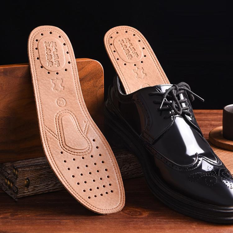 Tan leather insole displayed beside a black dress shoe, perforated arch support