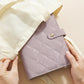 Purple quilted jewelry organizer book with button strap and hinged cover