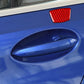 Red carbon-fiber door pillar sticker on blue car door near handle recess