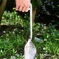 Stainless steel fishing pliers clamping a fish during outdoor fishing