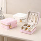 Opened travel jewelry organizer pouch with compartments holding necklaces, rings, and earrings.