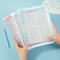 Clear PVC zipper pouch with light blue border, open binder rings, and four-pocket pages