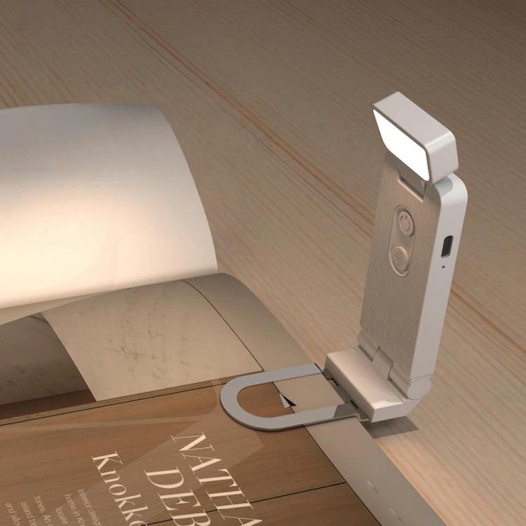 Light gray clip-on LED mini bookmark lamp clamped to a desk edge