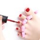 Nail care accessory with red-tipped tool and pink toe spacers