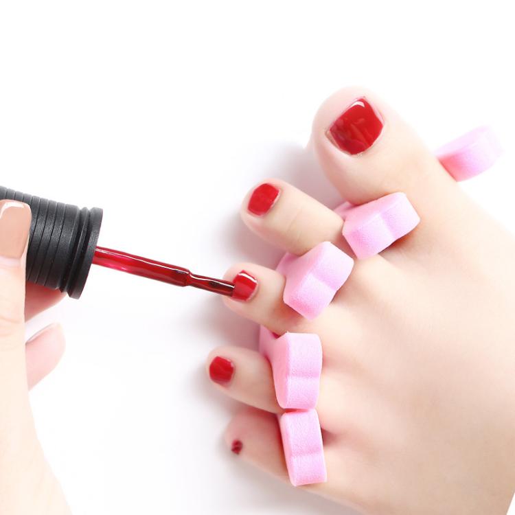 Nail care accessory with red-tipped tool and pink toe spacers