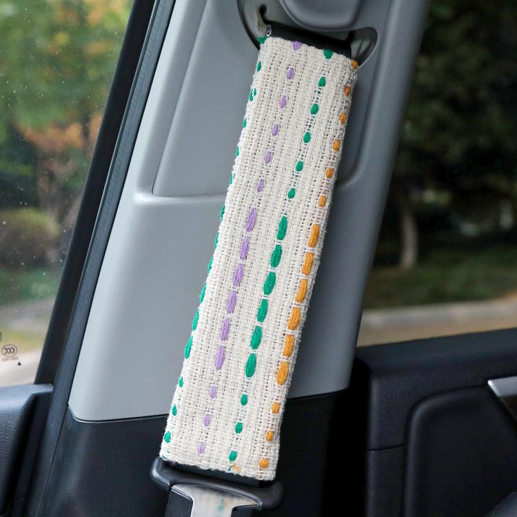 Car seat belt shoulder cover in white fabric with multicolor dotted stripes