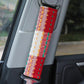 Car seat belt shoulder cover in red fabric with green, orange, and white dotted stripes