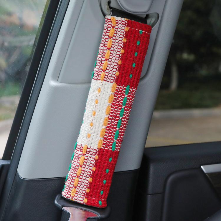 Car seat belt shoulder cover in red fabric with green, orange, and white dotted stripes