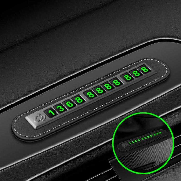 Car dashboard parking phone number sign with red stitched edge and green digits
