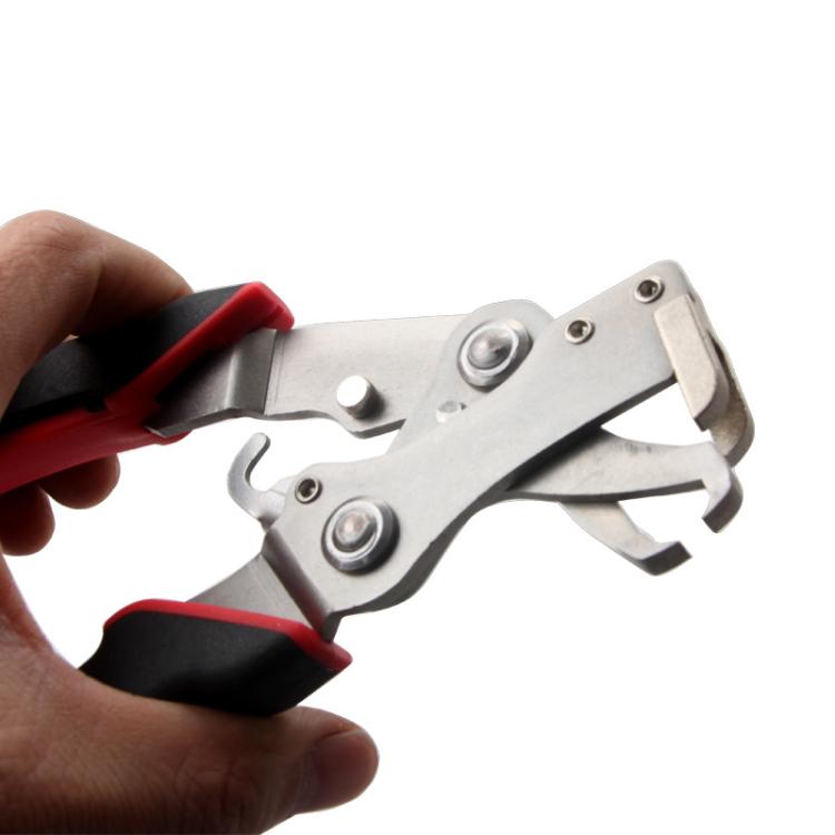 Panel removal tool held in hand; red/black grips and metal gripping jaws