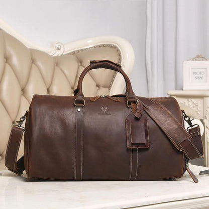 Brown leather travel tote bag with dual handles, detachable shoulder strap, front pocket.