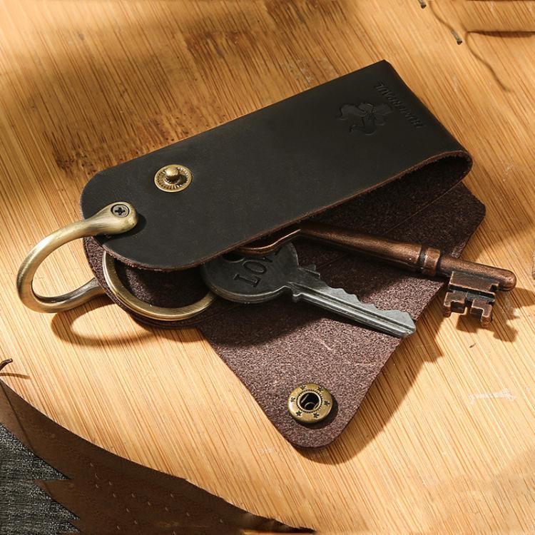 Leather key pouch holding keys with metal keyring and snap button closure