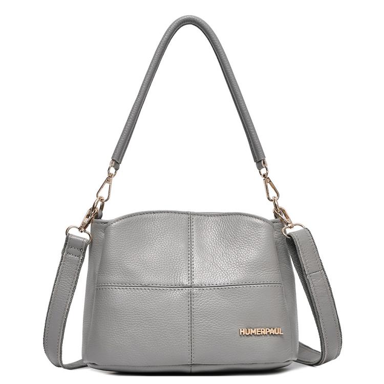 Gray leather shoulder bag with top handles and crossbody strap, front logo patch