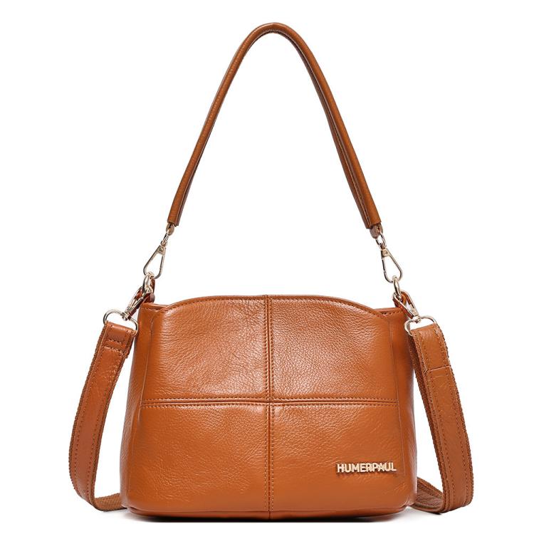 Light brown leather shoulder bag with top handles and crossbody strap, front logo patch