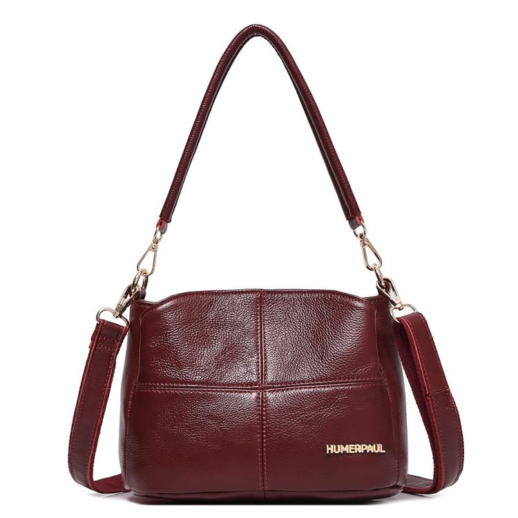 Red leather shoulder bag with top handles and crossbody strap, front logo patch