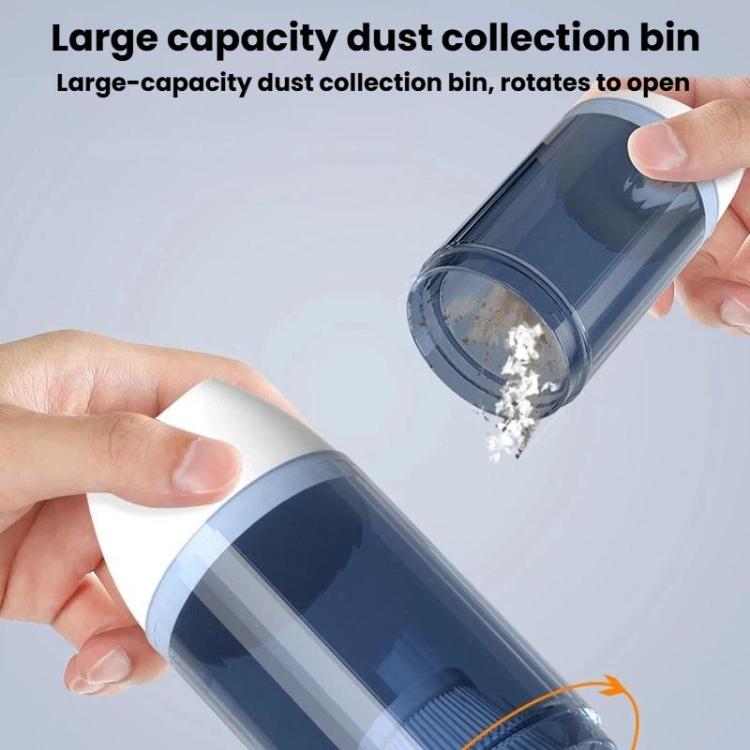 Handheld vacuum cleaner with open rotating dust collection bin showing debris