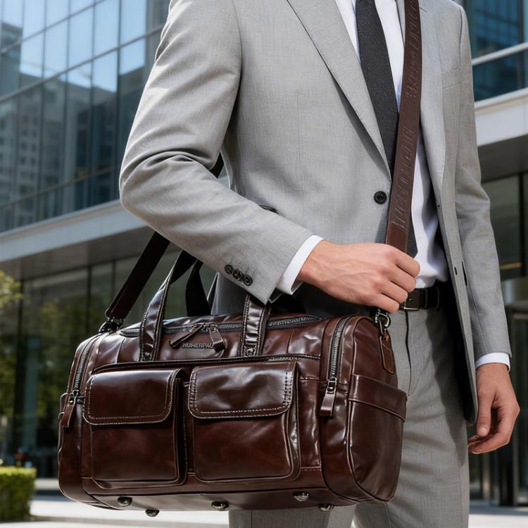 Brown leather travel duffel bag with front compartments and adjustable shoulder strap