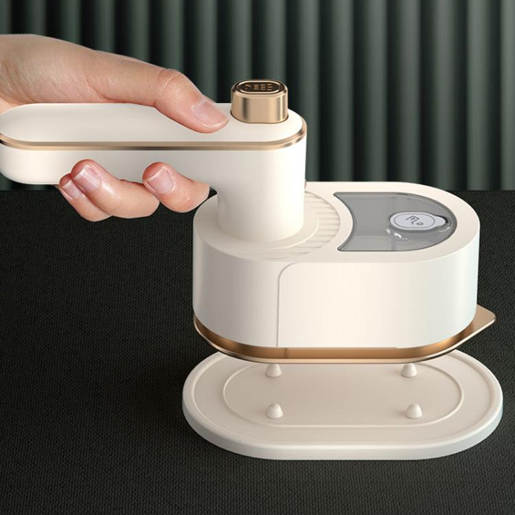 White handheld garment steamer being held above fabric on a base stand