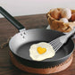 Stainless steel slotted spatula with angled fork head in a nonstick pan