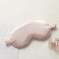 Light pink satin sleep eye mask with elastic strap, smooth double-sided fabric.