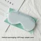 Light aqua satin sleep mask with elastic strap, double-sided light-blocking design.
