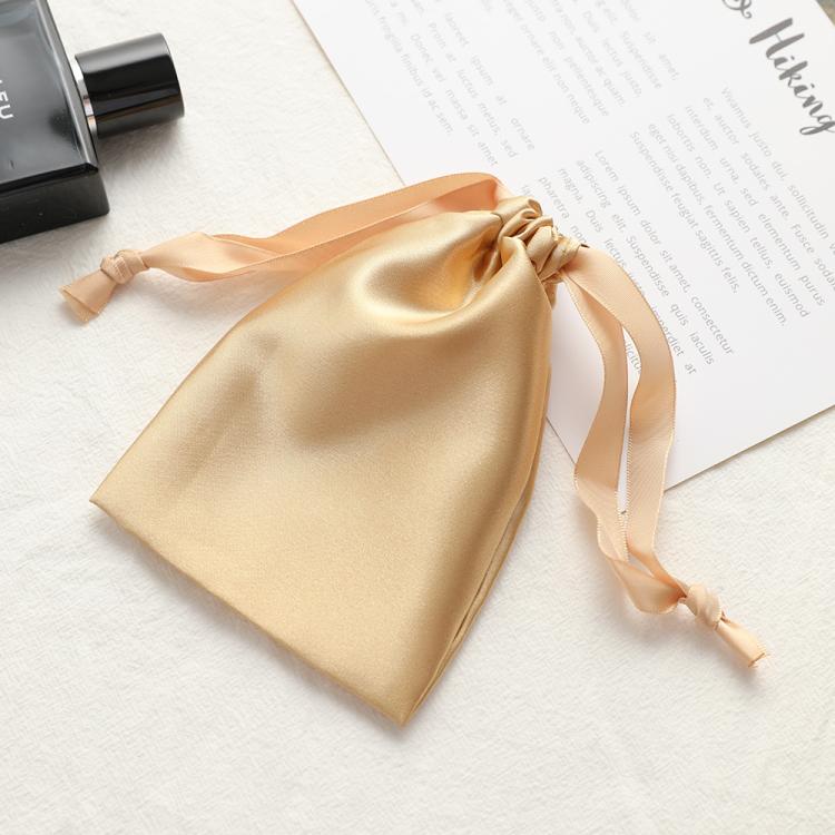 Champagne satin drawstring pouch for small jewelry, gathered top with ribbon ties.