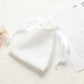 White satin drawstring pouch for small jewelry, gathered top with ribbon ties.