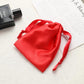 Red satin drawstring pouch for small jewelry, gathered top with ribbon ties.