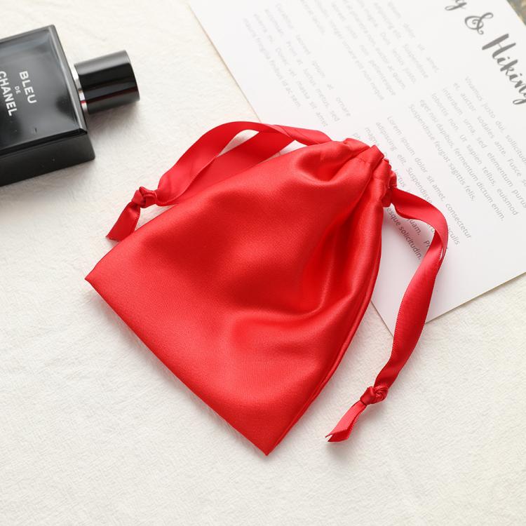 Red satin drawstring pouch for small jewelry, gathered top with ribbon ties.
