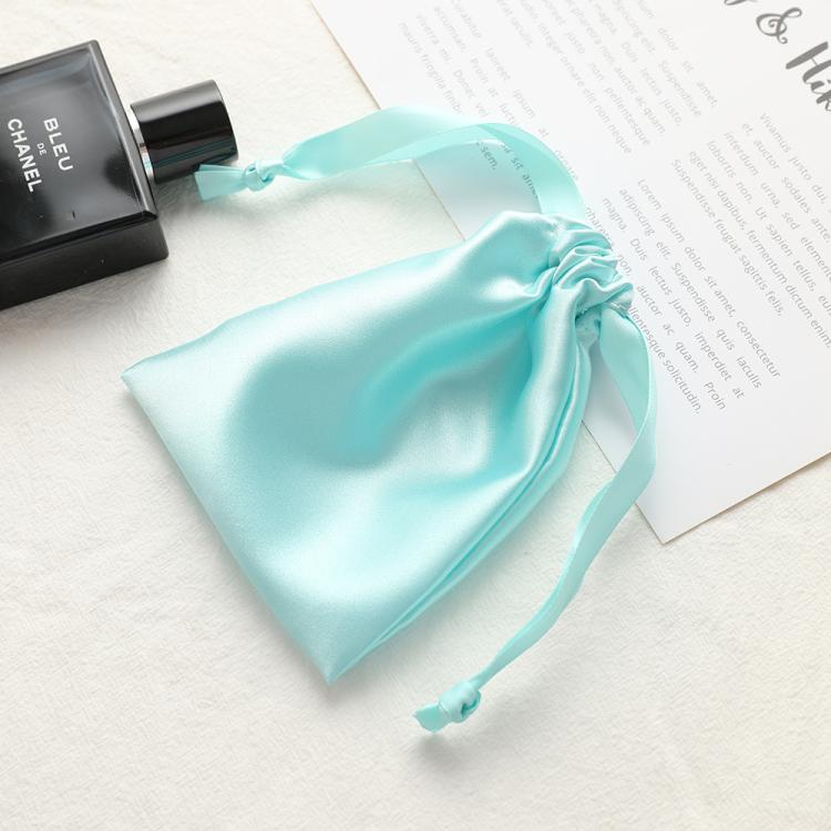 Light aqua satin drawstring pouch for small jewelry, gathered top with ribbon ties.