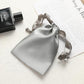 Silver gray satin drawstring pouch for small jewelry, gathered top with ribbon ties.