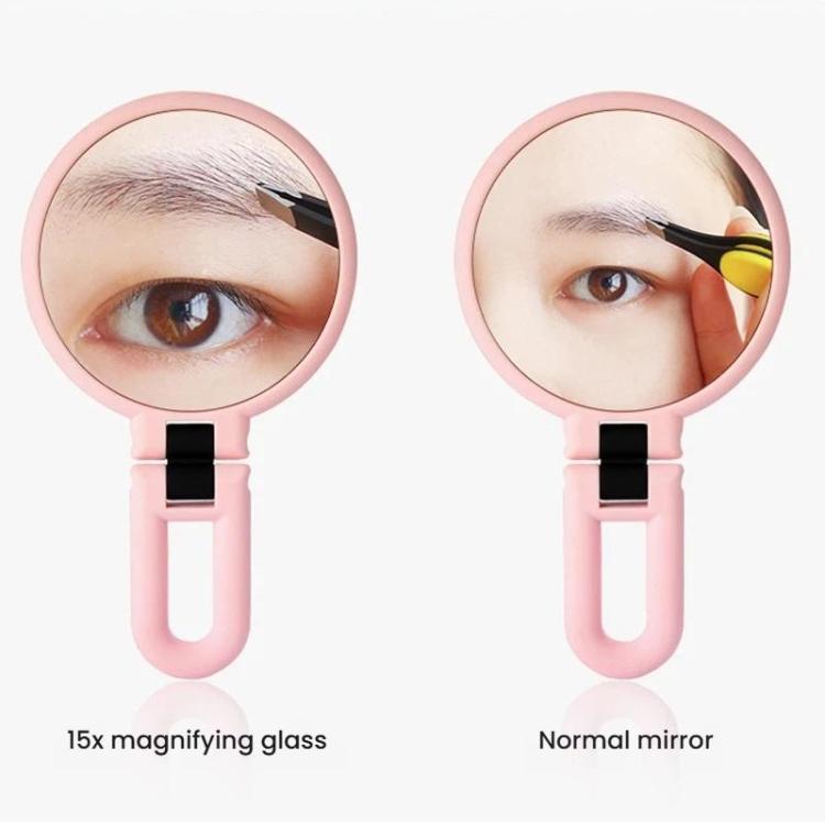 Pink double-sided vanity mirror with handle shown in close-up eye makeup