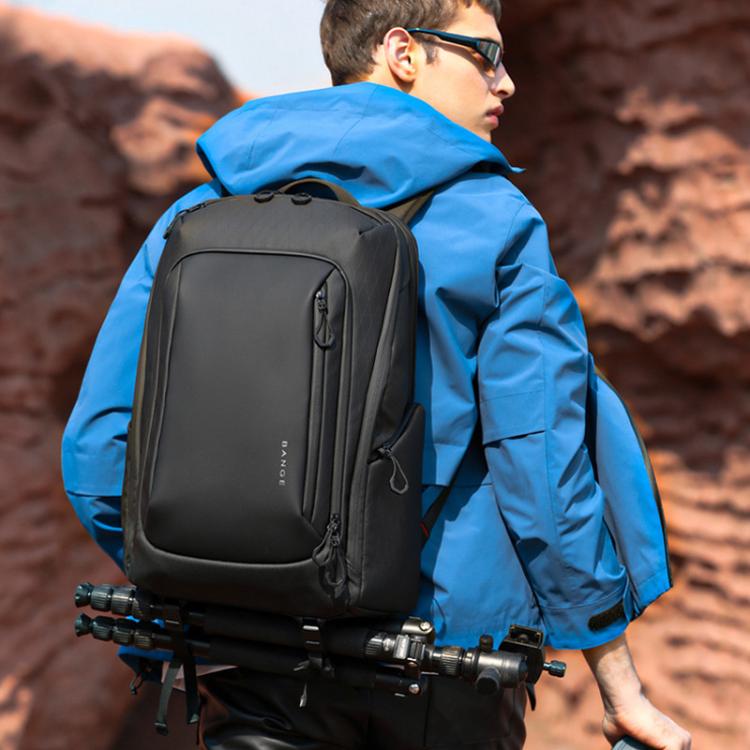 Black camera commuter backpack worn with padded shoulder straps and side zipper.