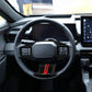 Steering wheel adjustment button trim cover with dark bezel and red accent stripe