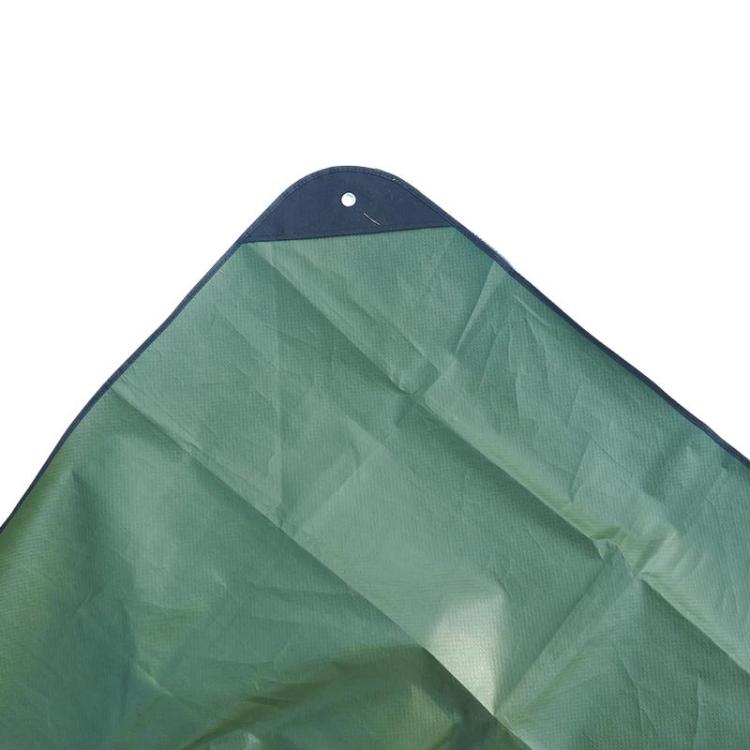 Green emergency blanket tarp close-up with dark border and grommet
