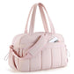 Light pink travel bag with compartments, padded strap, and zippered front pocket