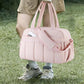 Pink travel duffel bag with front compartments, adjustable side straps, carry handles