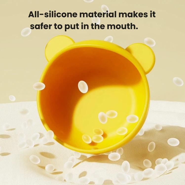 Orange-and-yellow all-silicone toddler feeding bowl with suction base, rounded interior.