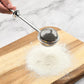 Stainless steel tea infuser sphere strainer over loose tea on a wooden board