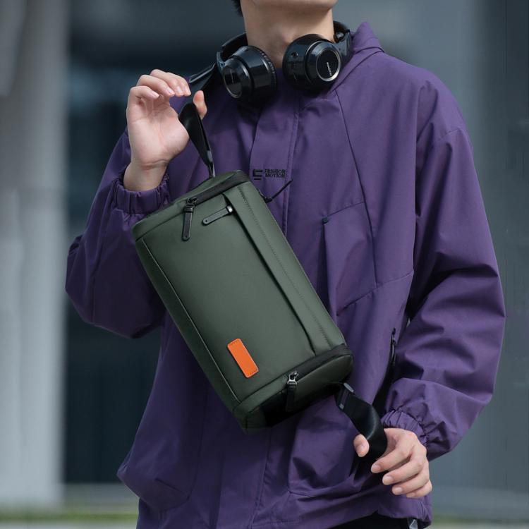 Green crossbody bag worn on a person’s shoulder with adjustable strap
