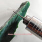 Electroplated diamond drill bit cutting a green stone with extended metal shaft