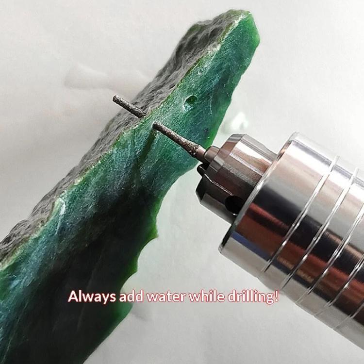 Electroplated diamond drill bit cutting a green stone with extended metal shaft