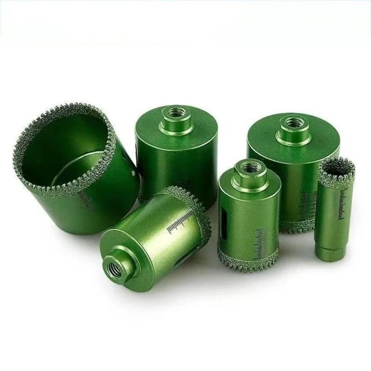 Set of green tile hole saw drill bits with serrated diamond cutting rims