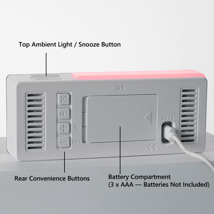 Grey alarm clock rear panel with buttons, battery compartment, and power cable port