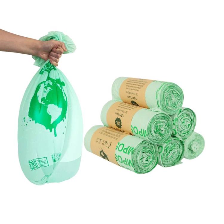 Compostable PLA garbage bags, light green roll pack and hand holding a filled bag