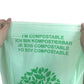 Compostable PLA garbage bag with green text and leaf logo on light green plastic
